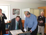 Watched over by Vince Williams and Danny Toplis, Peter Hartup shows SHFT Executive Officer Geoff Bailey one of the historical photo albums from the collection. Peter is heading up the digitisation program in the library.